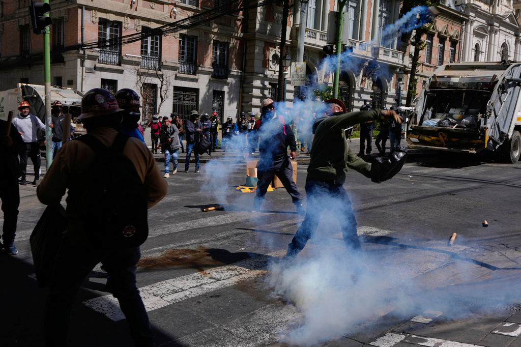 A protester returns a tear gas canister to police during an anti-government protest in La Paz, Bolivia, Monday, May 18, 2026. (AP Photo/Juan Karita)
