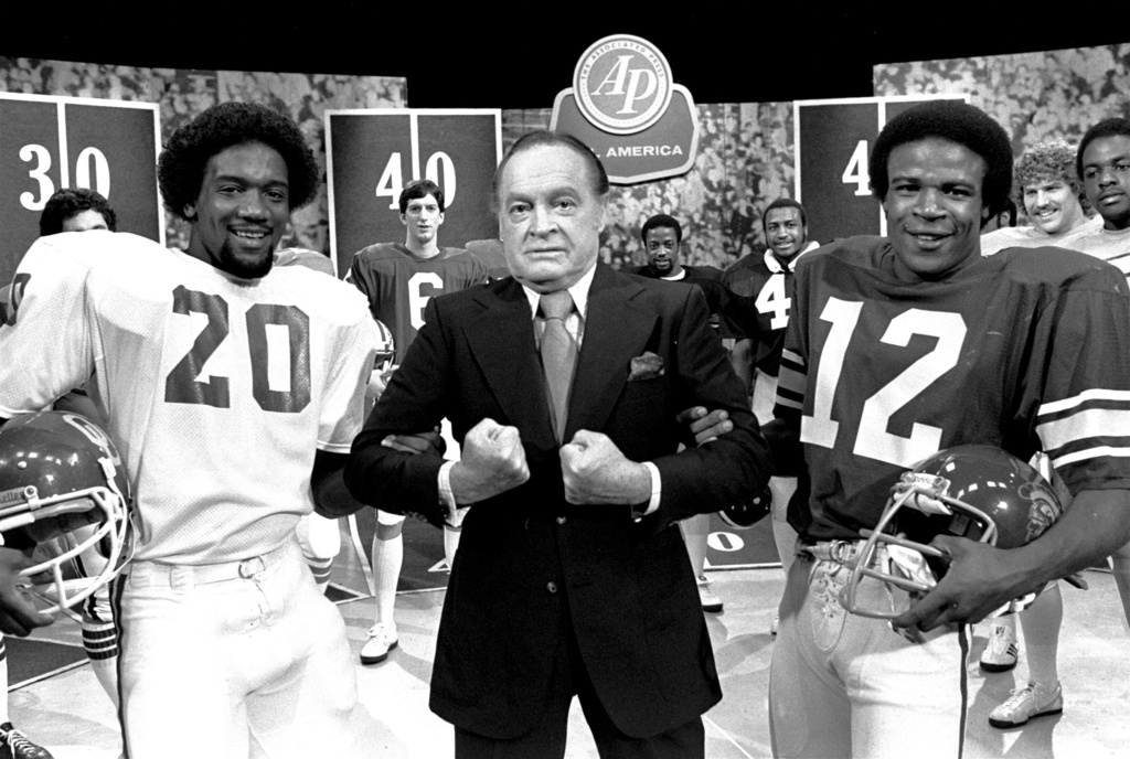 FILE - Comedian Bob Hope is pictured at a taping session Monday, Dec. 10, 1979, in NBC's Burbank Studios with members of the Associated Press All-America football team. With Hope are: Billy Sims of Oklahoma, left, and Charles White of USC, Heisman Trophy winner. Sims won the Heisman Trophy in 1978. (AP Photo/Wally Fong, File)