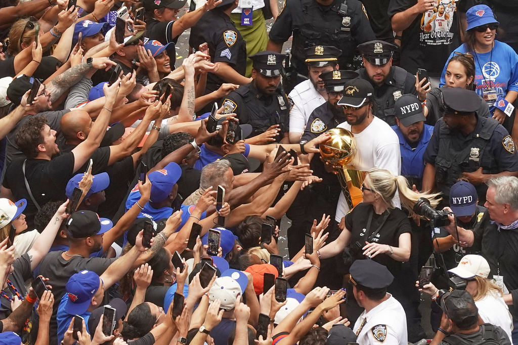 Jalen Brunson, upper right, of the NBA Champion New York Knicks carries the trophy for fans during the ticker-tape parade on Broadway, in New York's "Canyon of Heroes," Thursday, June 18, 2026. (AP Photo/Richard Drew)