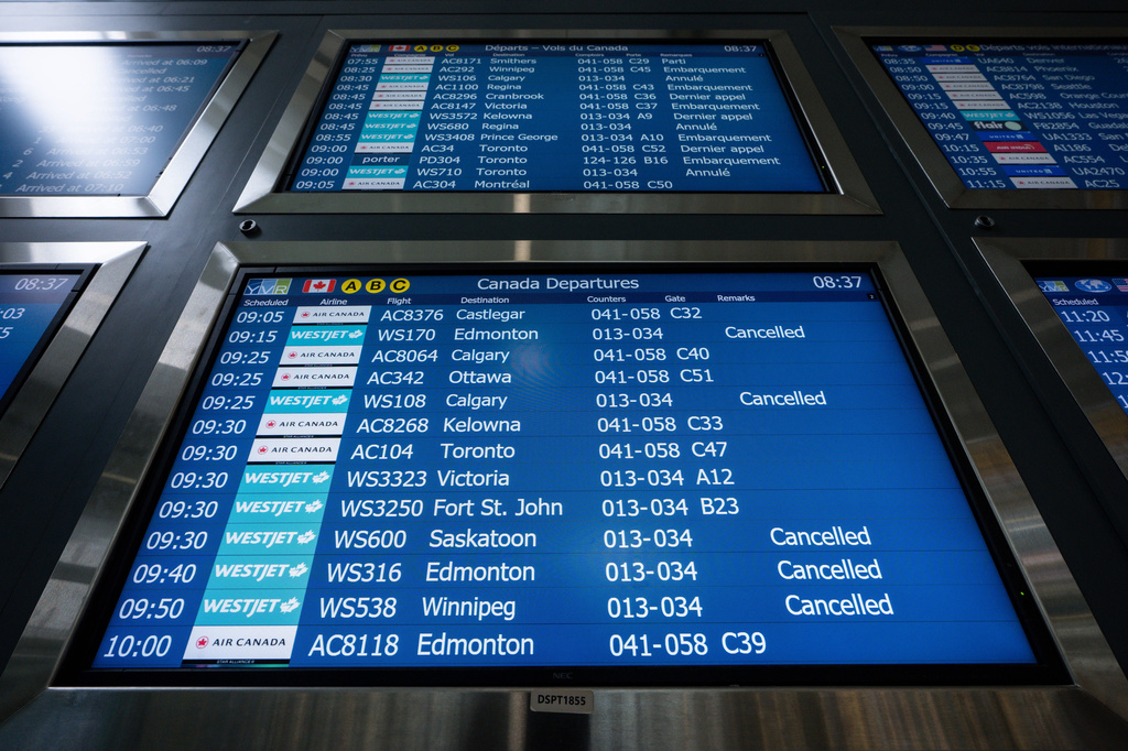 WestJet flights are pictured cancelled on an information board at Vancouver International Airport in Richmond, British Columbia, Sunday, Aug. 2, 2026. (Ethan Cairns/The Canadian Press via AP)