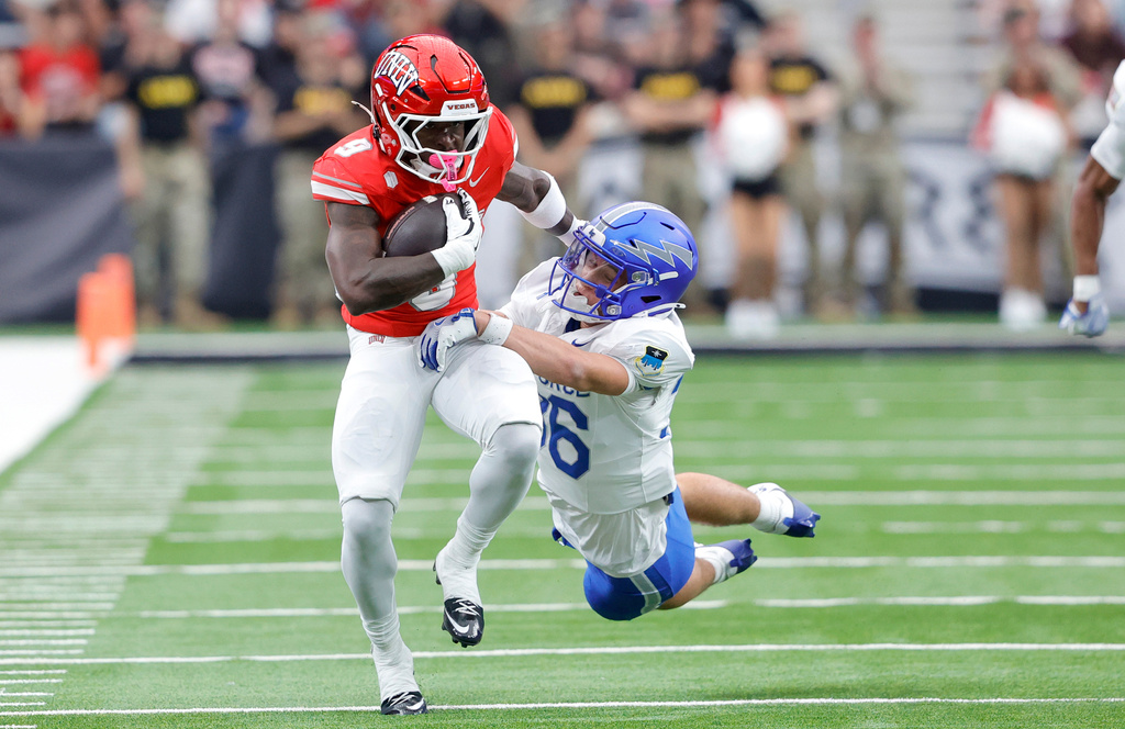 UNLV running back Jai'Den Thomas (9) is tackled by Air Force defensive back Max Mustell (36) during the first half of an NCAA football game Saturday, Oct. 11, 2025, in Las Vegas. (Steve Marcus/Las Vegas Sun via AP)