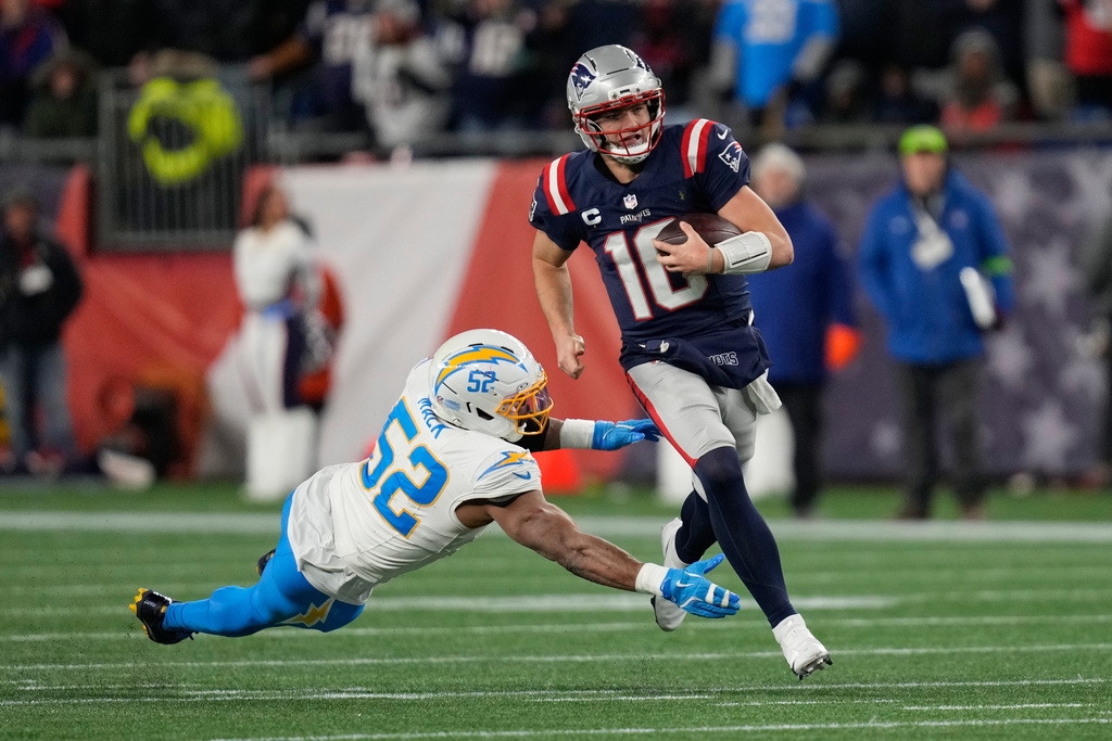 New England Patriots quarterback Drake Maye (10) avoids a tackle by Los Angeles Chargers linebacker Khalil Mack (52) in the first half of an NFL wild-card playoff football game in Foxborough, Mass., Sunday, Jan. 11, 2026. (AP Photo/Charles Krupa)