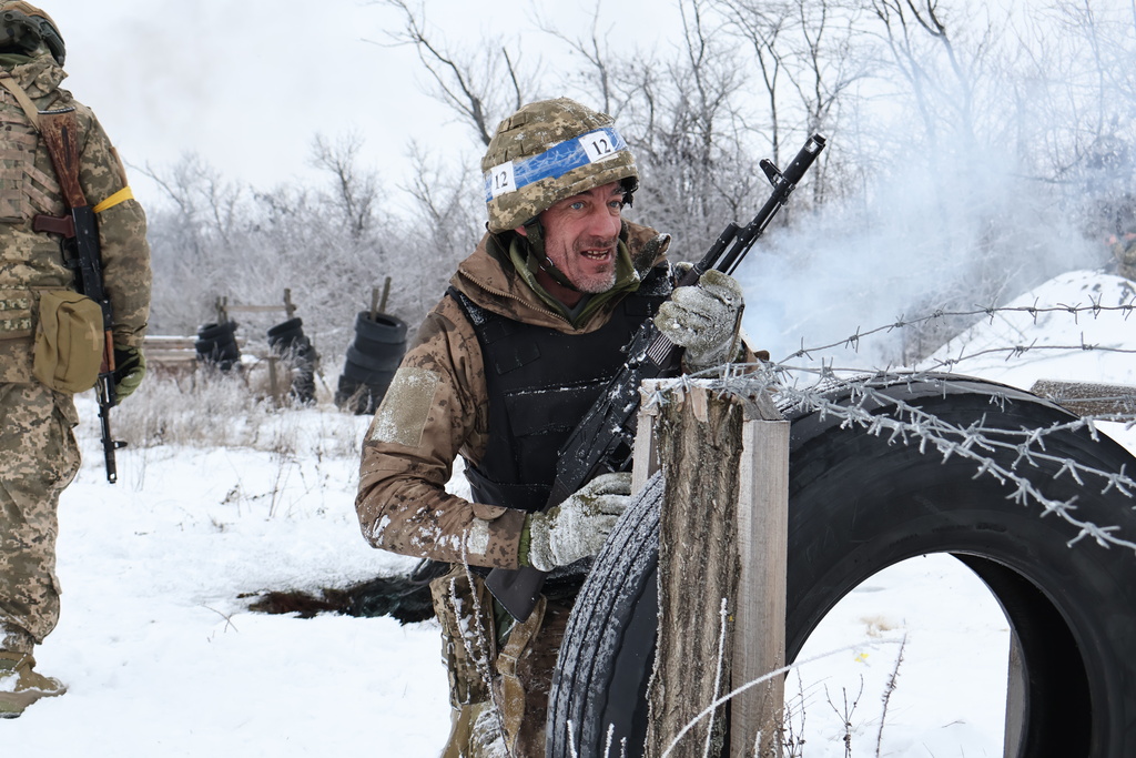 In this photo provided by Ukraine's 65th Mechanized Brigade press service, recruits perform drills at a training ground in the Zaporizhzhia region, Ukraine, Thursday, Jan. 1, 2026. (Andriy Andriyenko/Ukraine's 65th Mechanized Brigade via AP)
