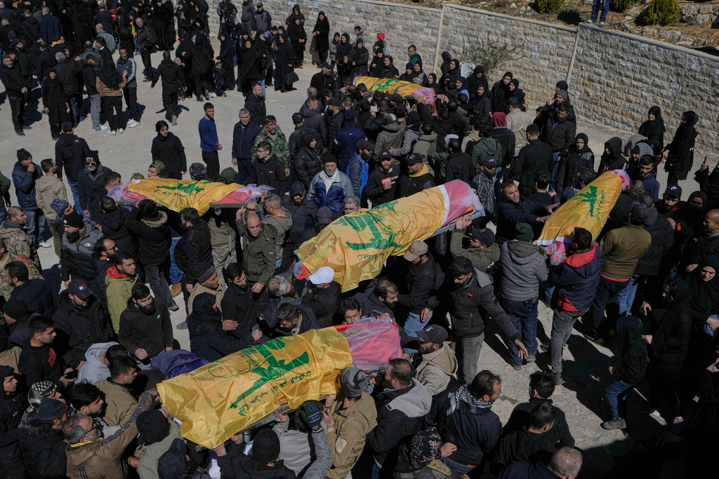 Mourners carry the bodies of Hezbollah fighters who were killed by Israeli airstrikes during their funeral procession in Khraibeh village, eastern Lebanon, Sunday, March 8, 2026. (AP Photo/Bilal Hussein)