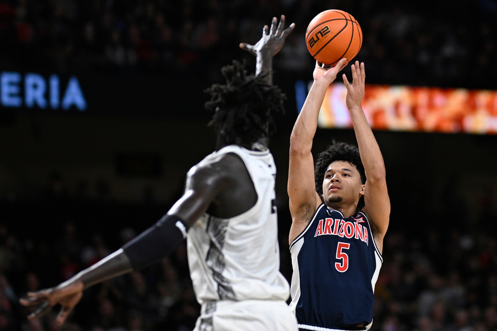 Arizona guard Brayden Burries (5) goes up to shoot as Central Florida center John Bol (7) defends during the first half of an NCAA college basketball game, Saturday, Jan. 17, 2026, in Orlando, Fla. (AP Photo/Phelan M. Ebenhack)