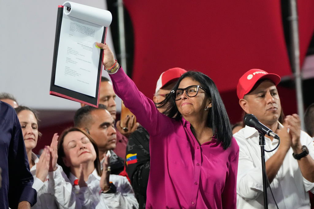 Venezuela's acting President Delcy Rodriguez takes part in a rally holding up a copy of a new law after lawmakers approved legislation opening the nation's oil sector to privatization, at the Miraflores Palace in Caracas, Venezuela, Thursday, Jan. 29, 2026. (AP Photo/Ariana Cubillos)