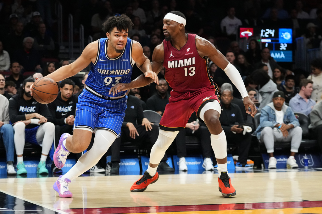 Miami Heat center Bam Adebayo (13) defends Orlando Magic forward Noah Penda (93) during the first half of an NBA basketball game Wednesday, Jan. 28, 2026, in Miami. (AP Photo/Marta Lavandier)