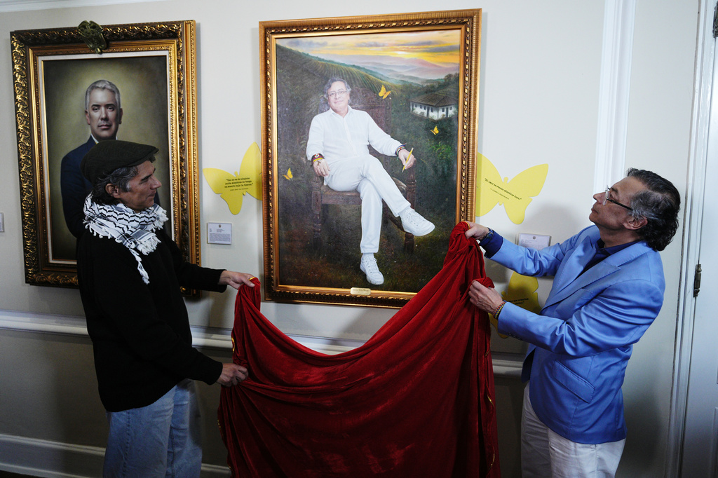 Colombia's President Gustavo Petro unveils his portrait, painted by Jaime Rojas, left, in the gallery of Colombian former presidents during his final week in office at the presidential palace in Bogota, Colombia, Monday, Aug. 3, 2026. (AP Photo/Ivan Valencia)