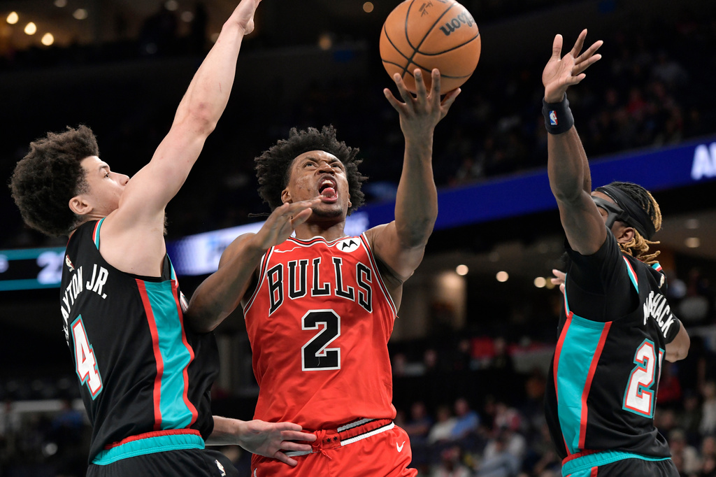 Chicago Bulls guard Collin Sexton (2) shoots between Memphis Grizzlies guards Walter Clayton Jr. (4) and Jahmai Mashack, right, in the first half of an NBA basketball game Saturday, March 28, 2026, in Memphis, Tenn. (AP Photo/Brandon Dill)