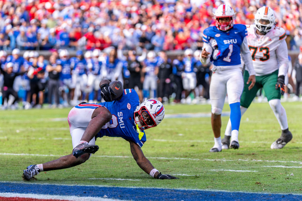 SMU safety Ahmaad Moses intercepts a pass as defensive end Isaiah Smith and Miami offensive lineman Anez Cooper look on during overtime of an NCAA college football game, Saturday, Nov. 1, 2025, in Dallas. SMU won 26-20. (AP Photo/Jeffrey McWhorter)