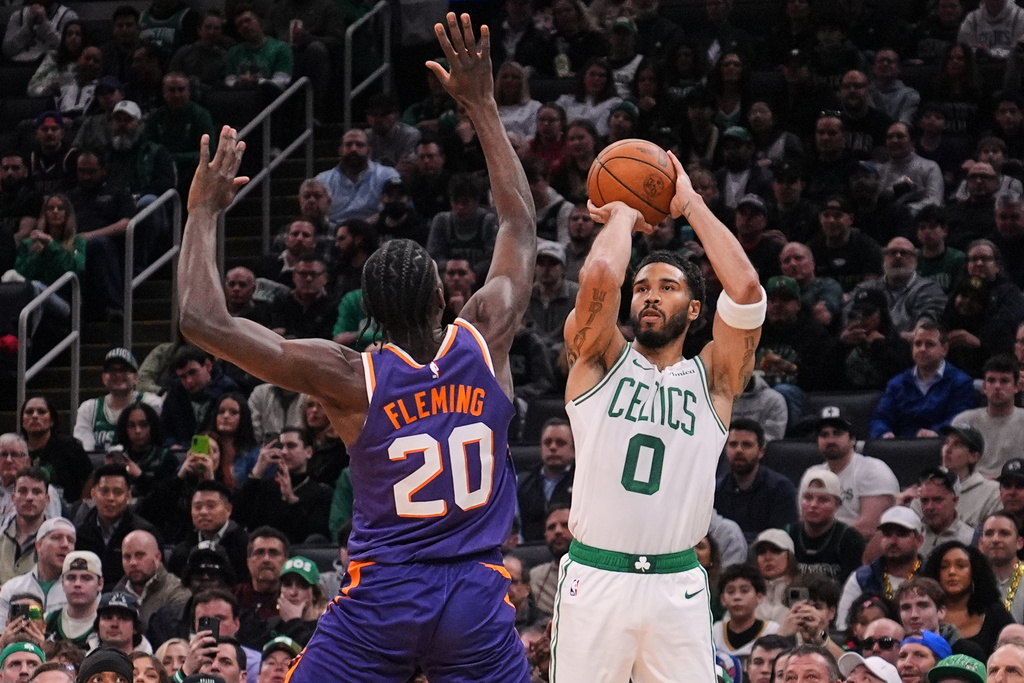 Boston Celtics forward Jayson Tatum (0) takes a 3-point shot over Phoenix Suns forward Rasheer Fleming (20) during the first half of an NBA basketball game, Monday, March 16, 2026, in Boston. (AP Photo/Charles Krupa)