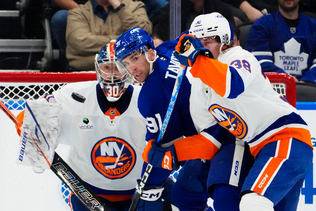 New York Islanders goaltender Ilya Sorokin (30) watches the puck as Toronto Maple Leafs' John Tavares (91) battles with Victor Eklund (38) during the first period of an NHL hockey game in Toronto, Wednesday, Sept. 30, 2026. (Frank Gunn/The Canadian Press via AP)