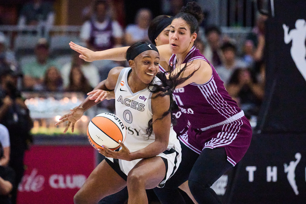 Las Vegas Aces' Jackie Young (0) drives past Toronto Tempo's Kia Nurse (11) during the first half of a WNBA basketball game in Toronto, on Monday, July 20, 2026. (Sammy Kogan/The Canadian Press via AP)