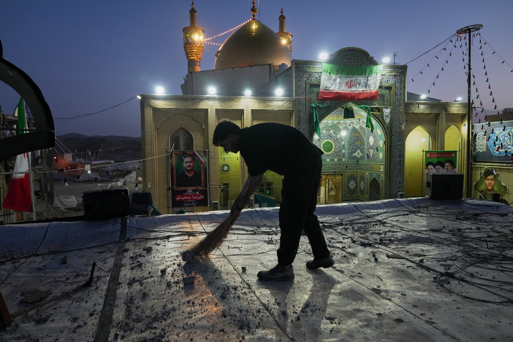 A worker cleans an area within the Grand Hosseiniyeh complex, with the mosque visible in the background, that officials say was hit by U.S.-Israeli airstrikes Tuesday in Zanjan, Iran, Saturday, April 4, 2026. (AP Photo/Francisco Seco)