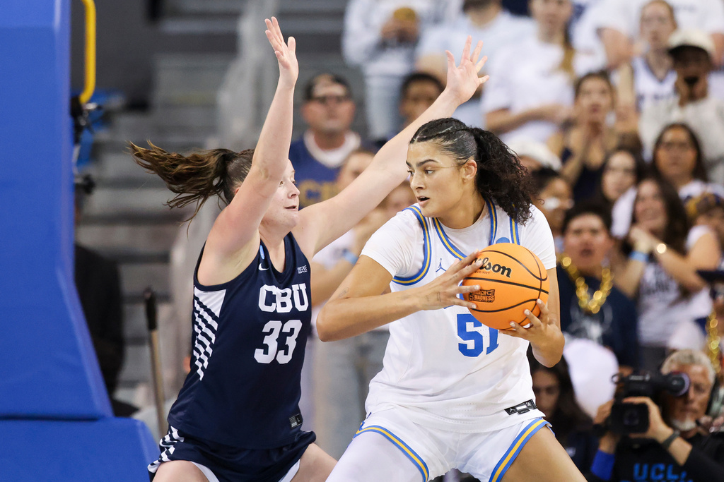 UCLA center Lauren Betts (51) drives against California Baptist forward Grace Schmidt (33) during the first half in the first round of the NCAA college basketball tournament, Saturday, March 21, 2026, in Los Angeles. (AP Photo/Jessie Alcheh)