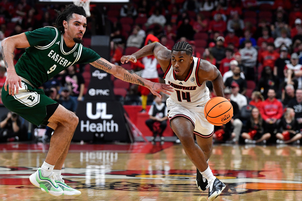 Louisville guard Adrian Wooley (14) attempts to drive past Eastern Michigan guard Addison Patterson (9) during the second half of an NCAA college basketball game in Louisville, Ky., Monday, Nov. 24, 2025. (AP Photo/Timothy D. Easley)