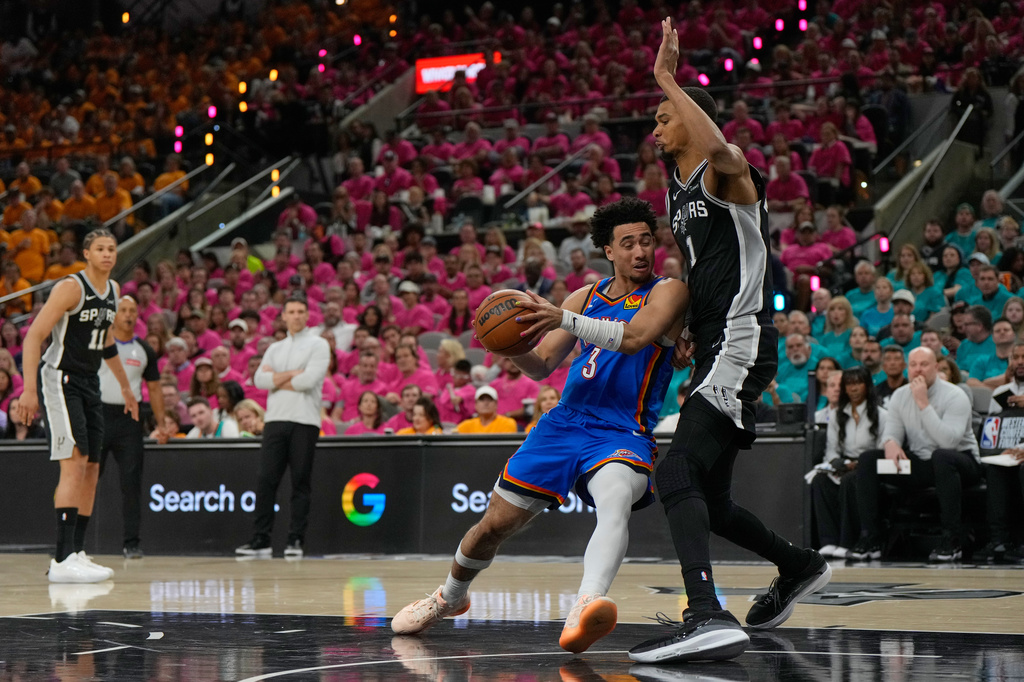 Oklahoma City Thunder guard Jared McCain (3) works toward the basket as San Antonio Spurs forward Victor Wembanyama (1) defends during the second half of Game 3 in the Western Conference finals NBA basketball playoffs series Friday, May 22, 2026, in San Antonio. (AP Photo/Ashley Landis)