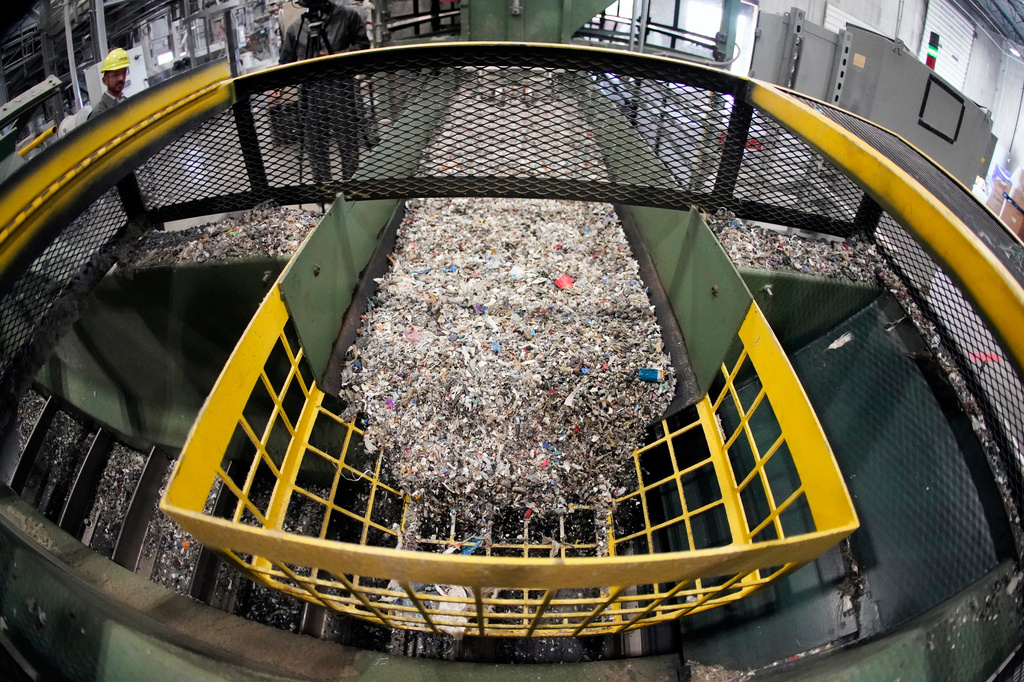 FILE - Ground up plastics that Alterra Energy receives from recycling facilities, move along a conveyor at the start of their process that transforms the material into a liquid that is then used in the manufacturing of plastic in Akron, Ohio, Sept. 8, 2022. (AP Photo/Keith Srakocic, File)