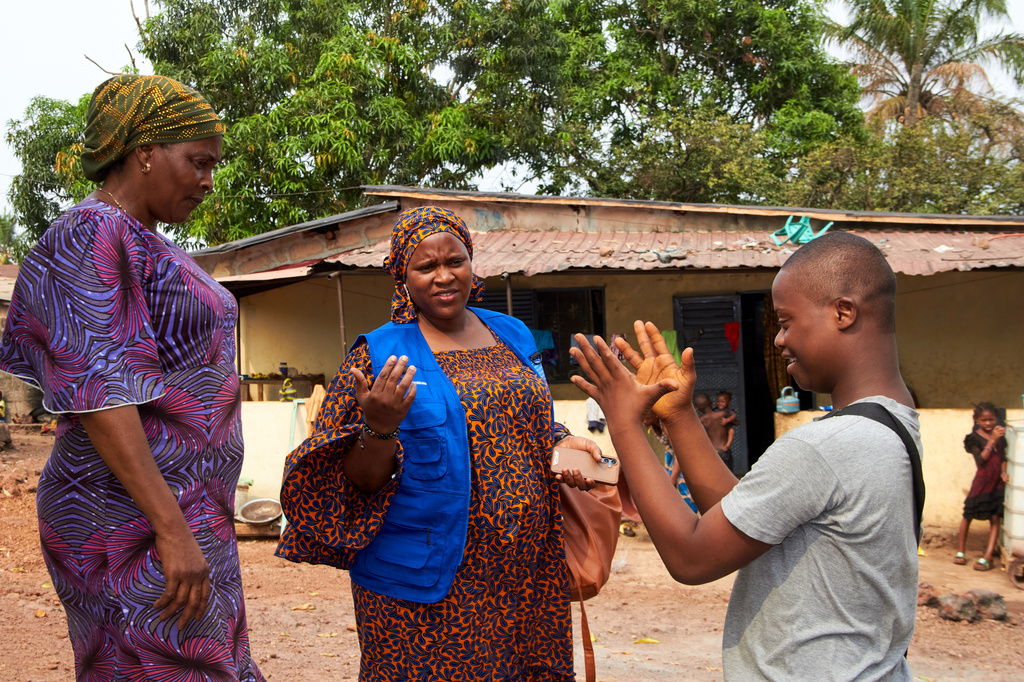 Kazaliou Balde, right, gestures outside his home while standing with his mother, Kadiatou Diallo, left, and Houssainatou Diallo, an advocate and communicator dedicated to supporting children with autism, in Fria, Guinea, Saturday, May 16, 2026. (AP Photo/Fode Toure)
