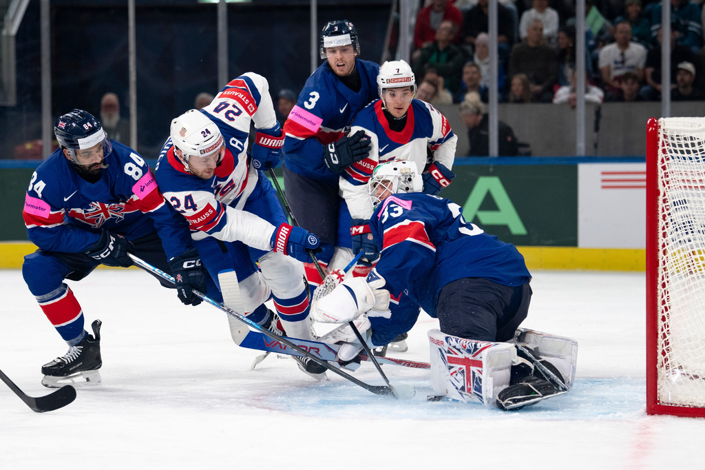 From left: Britain's Travis Brown, USA's Mathieu Olivier, Britain's Liam Steele, USA's Ryan Ufko and Britain's goaltender Ben Bowns fight for the puck, during the 2026 IIHF Men's Ice Hockey World Championship preliminary round group A game between Britain and the United States, in Zurich, Switzerland, Sunday, May 17, 2026. (Claudio Thoma/Keystone via AP)