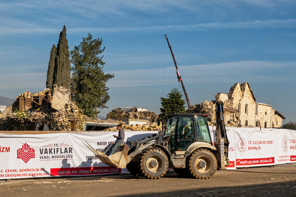 A construction vehicle passes the ruins of St. Paul Orthodox Church during debris removal efforts following the February 2023 earthquakes in Antakya, southern Turkey, Wednesday, Feb. 4, 2026. (AP Photo/Murat Kocabas)