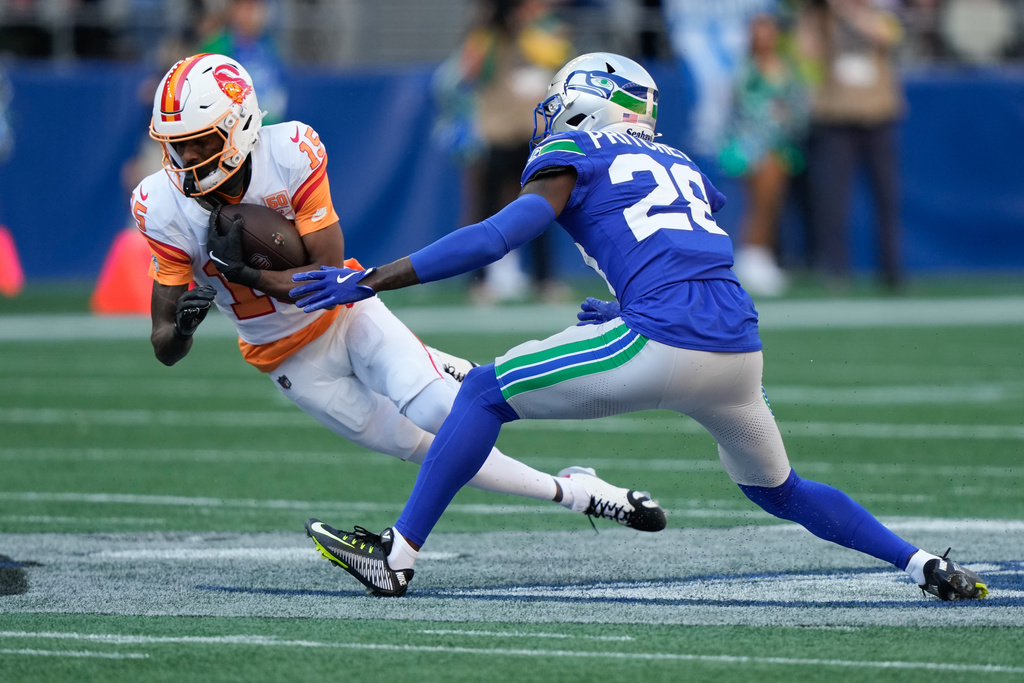 Tampa Bay Buccaneers wide receiver Tez Johnson (15) runs after making a catch as Seattle Seahawks cornerback Nehemiah Pritchett (28) defends during the second half of an NFL football game Sunday, Oct. 5, 2025, in Seattle. (AP Photo/Stephen Brashear)