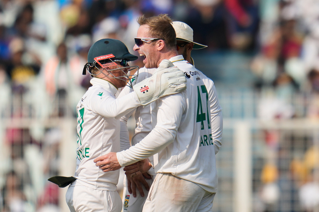 South Africa's Simon Harmer, right, celebrates with teammates after the dismissal of India's Kuldeep Yadav on the third day of the first cricket test match between India and South Africa in Kolkata, India, Sunday, Nov. 16, 2025. (AP Photo/Aijaz Rahi)
