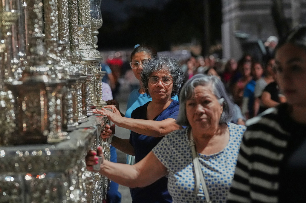 Members of the Corpus Christi Catholic Church push a large float that will carry the Lady of Hope Macarena during a rehearsal of their Good Friday procession Monday, March 23, 2026, in Miami, Fla. (AP Photo/Marta Lavandier)