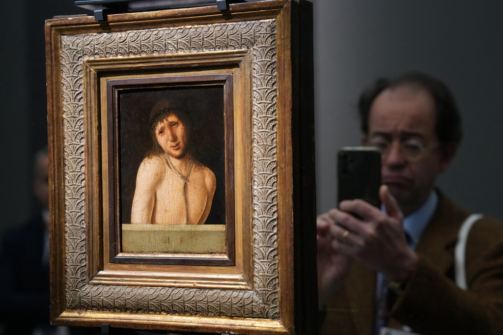 Journalists look at Antonello da Messina's Ecce Homo, a tempera-on-panel painting dating from around 1470 and measuring 20.3 by 14.9 centimeters, recently acquired by the Italian General Directorate of Museums for $14.9 million, or about 12.6 million euros in Rome, Thursday, March 26, 2026 . (AP Photo/Domenico Stinellis)