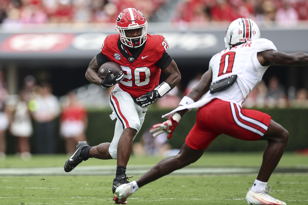 Georgia running back Dwight Phillips Jr. (20) carries the ball against Austin Peay defensive back Ellis Ellis Jr. (0) during the first half of an NCAA college football game against Austin Peay, Saturday, Sept. 6, 2025, in Athens, Ga. (AP Photo/Colin Hubbard)