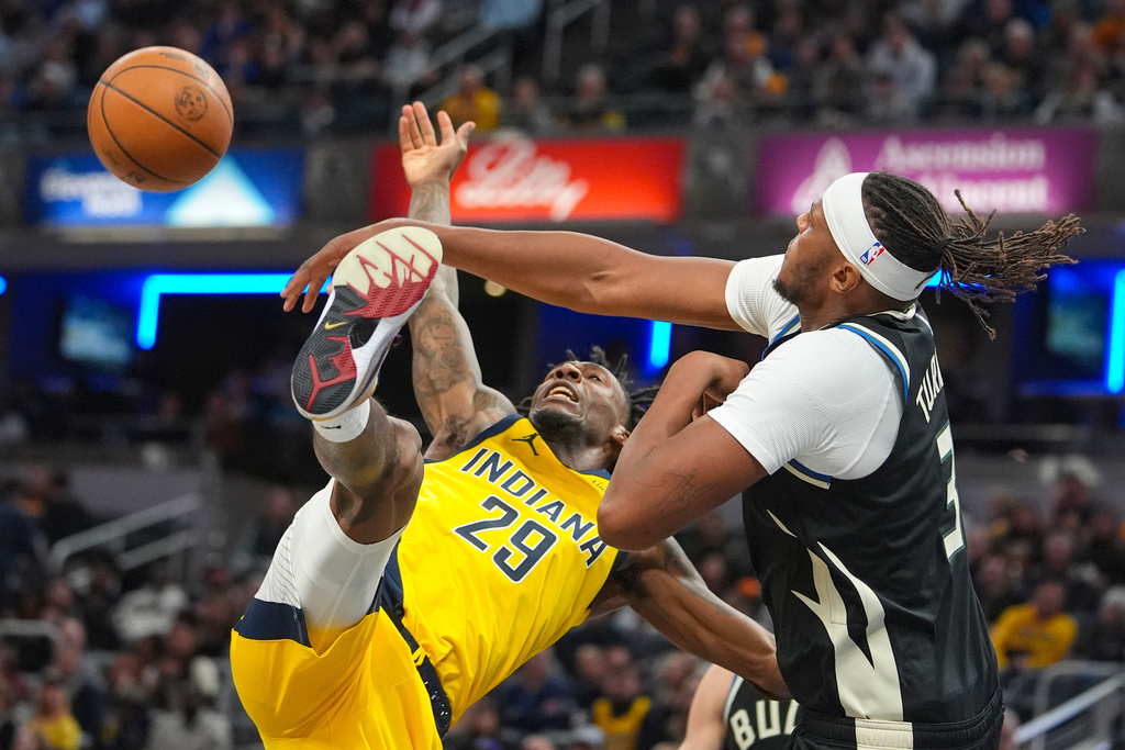 Milwaukee Bucks center/forward Myles Turner (3) fouls Indiana Pacers guard Quenton Jackson (29) as he shoots during the second half of an NBA basketball game in Indianapolis, Monday, Nov. 3, 2025. (AP Photo/Michael Conroy)