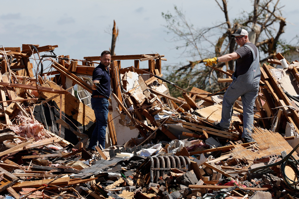 Men looks through damage Friday, April 24, 2026, in the Grayridge neighborhood that was damaged by a tornado Thursday in Enid, Okla. (AP Photo/Alonzo Adams)