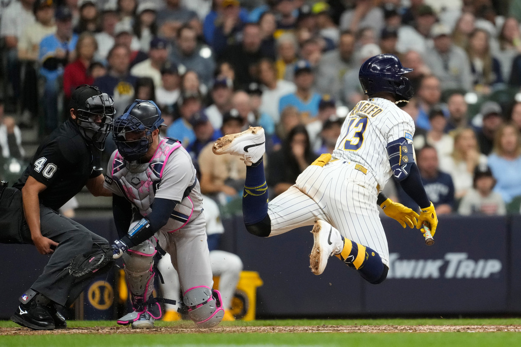 Milwaukee Brewers' Luis Rengifo, right, jumps out of the way of a pitch during the 10th inning of a baseball game against the New York Yankees, Saturday, May 9, 2026, in Milwaukee. (AP Photo/Aaron Gash)
