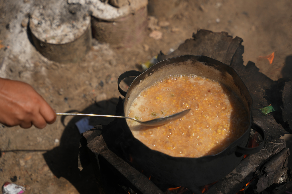 Palestinians use combustible materials collected from a garbage dump as fuel for cooking amid a shortage of cooking gas in Deir al-Balah, central Gaza Strip, Saturday, Aug. 22, 2026. (AP Photo/Abdel Kareem Hana)