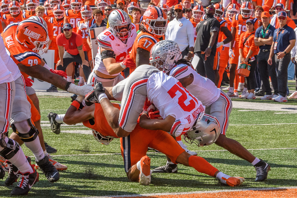 Ohio State running back CJ Donaldson (12) gets upended during the first half of an NCAA college football game against Illinois, Saturday, Oct. 11, 2025, in Champaign, Ill. (AP Photo/Craig Pessman)