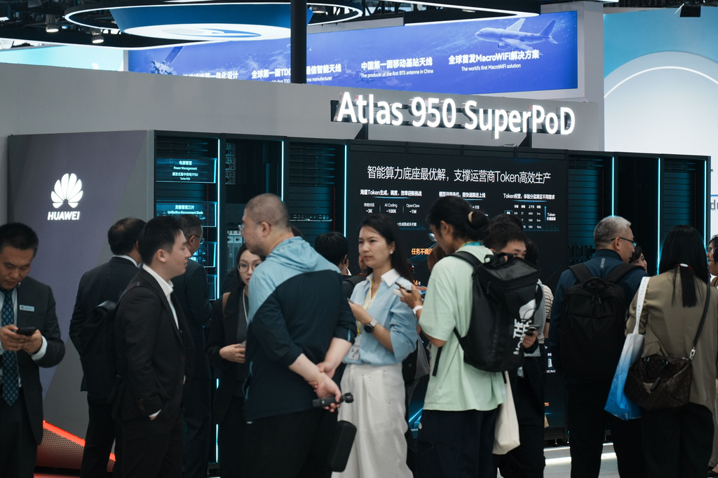 Visitors pass near the Atlas 950 SuperPod on display at the Huawei booth during the MWC26 in Shanghai, China on June 24, 2026. (Chinatopix via AP)