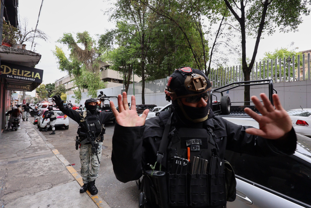 National Guards remove pedestrians by the General Prosecutor's headquarters in Mexico City, Sunday, Feb. 22, 2026, after the death of the leader of the Jalisco New Generation Cartel, Nemesio Rubén Oseguera Cervantes, known as "El Mencho." (AP Photo/Ginette Riquelme)