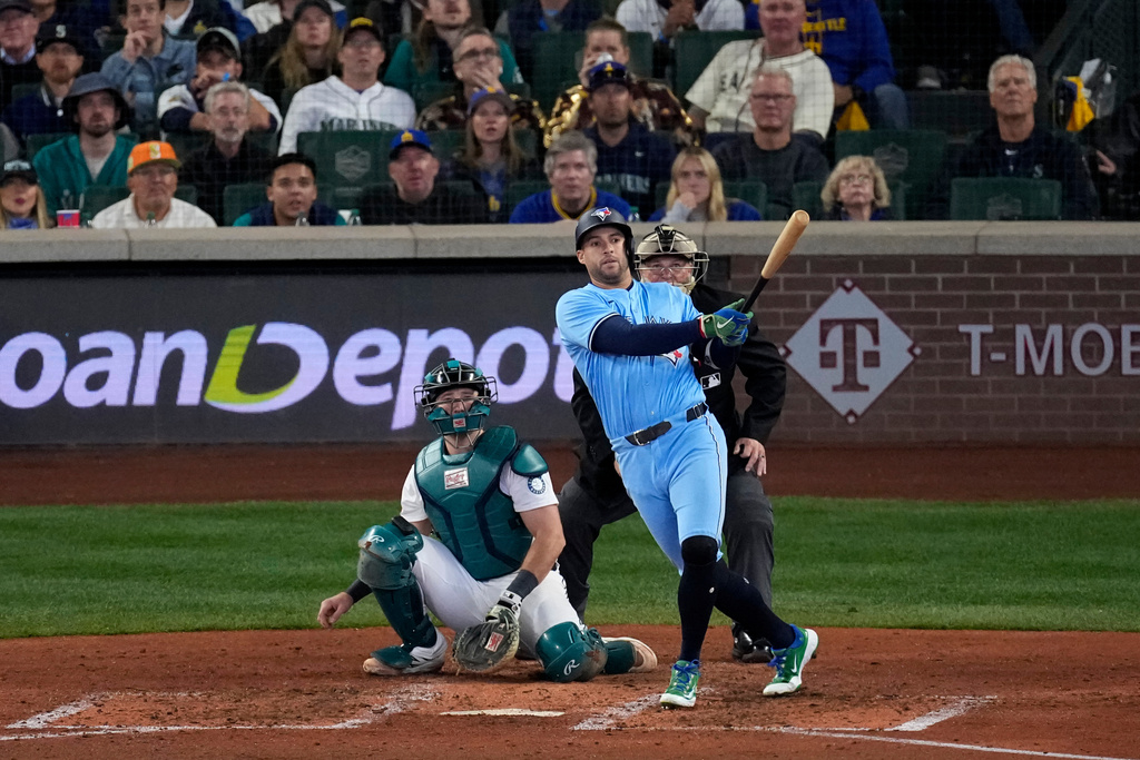 Toronto Blue Jays' George Springer follows through on an RBI double against the Seattle Mariners during the fifth inning in Game 5 of baseball's American League Championship Series, Friday, Oct. 17, 2025, in Seattle. (AP Photo/David J. Phillip)