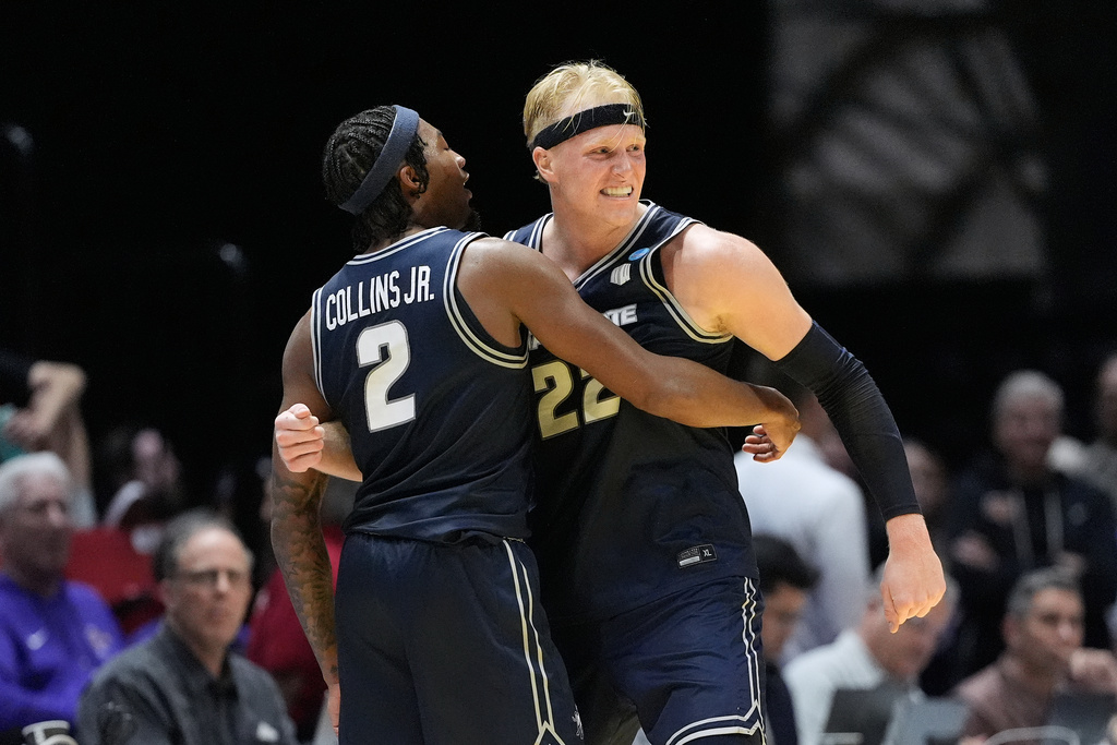 Utah State guard MJ Collins (2) celebrates with forward Karson Templin after the first round of the NCAA college basketball tournament against Villanova, Friday, March 20, 2026, in San Diego. (AP Photo/Mark J. Terrill)
