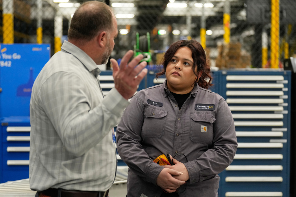 Walmart maintenance technician Liz Cardenas talks to R.J. Zanes, vice president of facility services, at a training area in a Walmart distribution center Thursday, Sept. 25, 2025, in Bentonville, Ark. (AP Photo/Charlie Riedel)