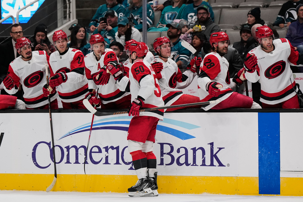 Carolina Hurricanes left wing Eric Robinson (50) celebrates with teammates after scoring a goal during the second period of an NHL hockey game against the San Jose Sharks, Tuesday, Oct. 14, 2025, in San Jose, Calif. (AP Photo/Godofredo A. Vásquez)