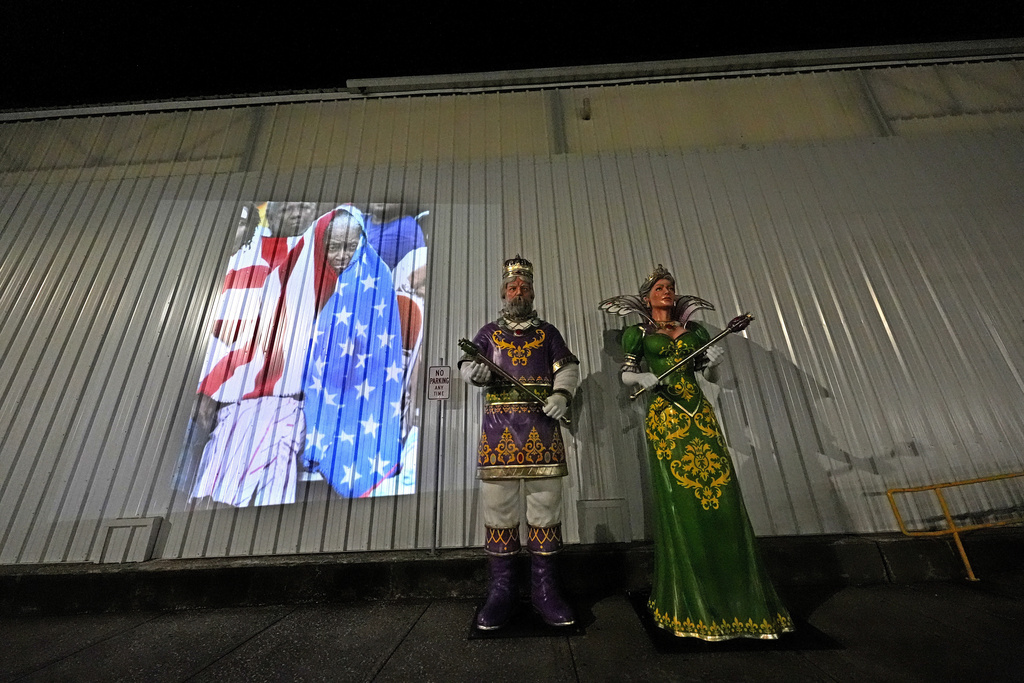 This photo of Milvertha Hendricks, 84, waiting in the rain with other flood victims outside the Ernest N. Morial Convention Center in New Orleans in the aftermath of Hurricane Katrina, taken by AP photographer Eric Gay, is projected Monday, Aug. 25, 2025, next to statues of the king and queen of Mardi Gras next to the center. (AP Photo/Gerald Herbert)