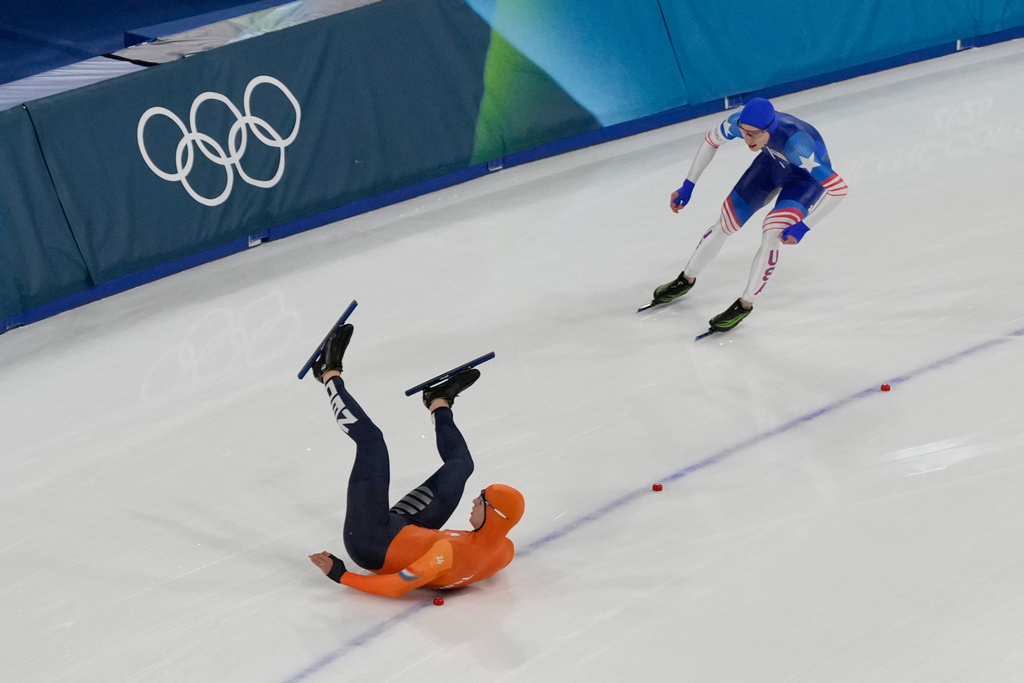 Netherlands' Jenning de Boo falls in front of United States' Jordan Stolz after competing in the men's 500-meters speedskating final at the 2026 Winter Olympics, in Milan, Italy, Saturday, Feb. 14, 2026. (AP Photo/David J. Phillip)