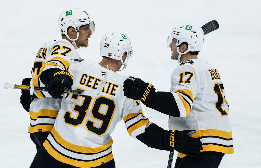 Boston Bruins' Hampus Lindholm (27), Morgan Geekie (39) and William Borgen (17) celebrate Lindholm's goal against the Winnipeg Jets during the first period of an NHL hockey game in Winnipeg, Manitoba, Friday, Oct. 2, 2026. (John Woods/The Canadian Press via AP)