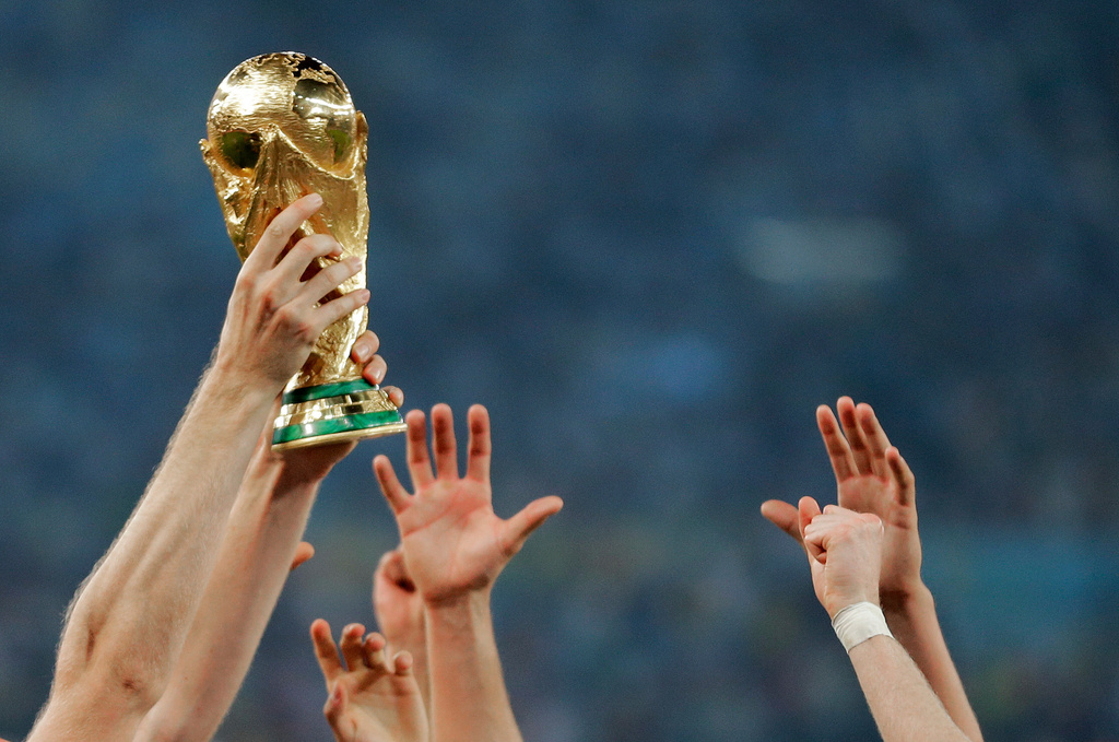 FILE - German players reach out to touch the trophy after the World Cup final soccer match between Germany and Argentina, in Rio de Janeiro, Brasil, July 13, 2014. (AP Photo/Matthias Schrader, File)
