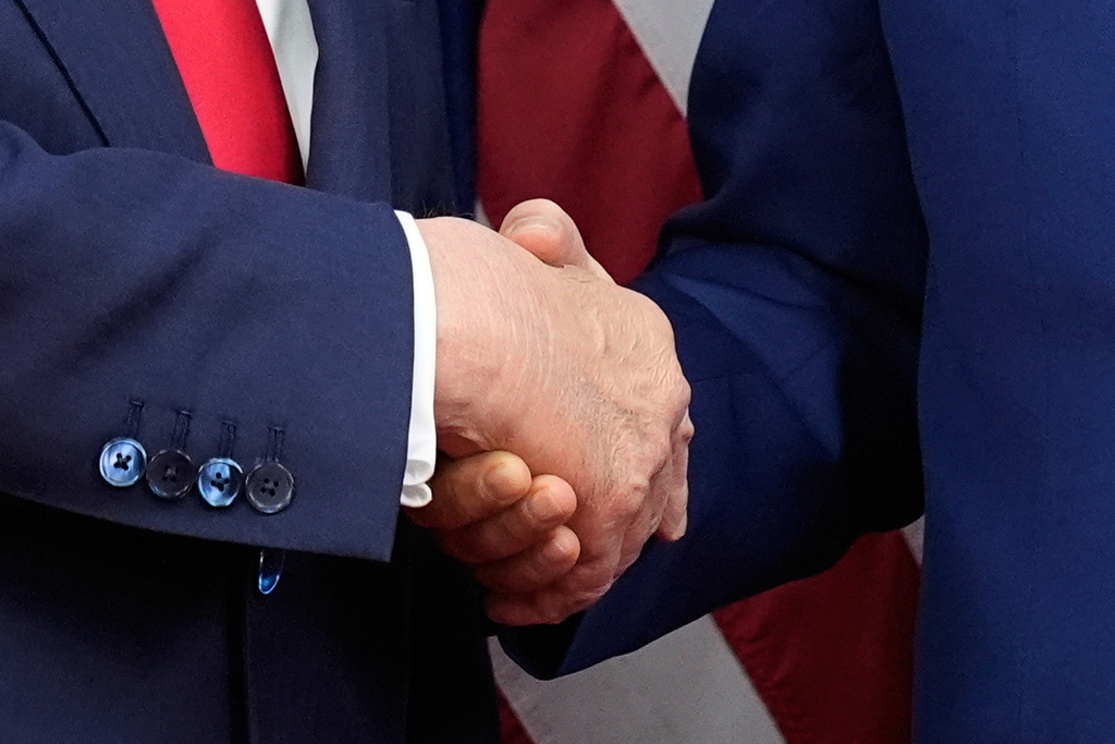 President Donald Trump, left, and Chinese President Xi Jinping, right, shake hands before their meeting at Gimhae International Airport in Busan, South Korea, Thursday, Oct. 30, 2025. (AP Photo/Mark Schiefelbein)