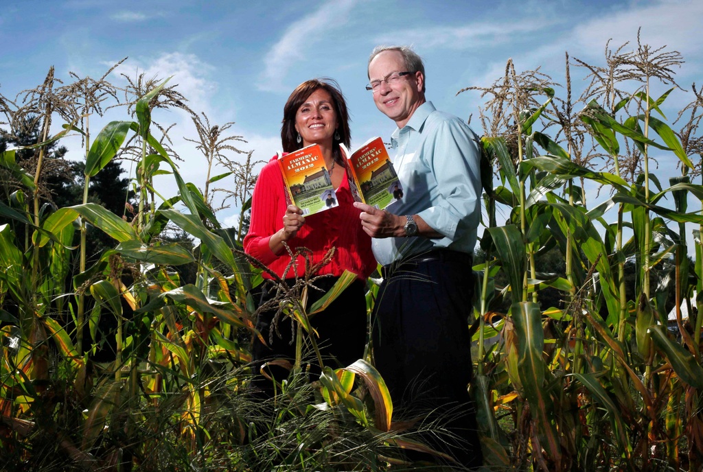 FILE - Farmers' Almanac editor Sondra Duncan and publisher Peter Geiger pose in a corn field with the 2012 edition of the almanac, Aug. 24, 2011, in Auburn, Maine. (AP Photo/Robert F. Bukaty, File)