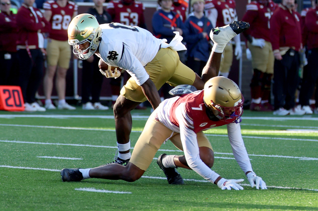 Notre Dame wide receiver Malachi Fields (0) stumbles over Boston College defensive back Carter Davis (7) while running for a touchdown during the first half of an NCAA college football game Saturday, Nov. 1, 2025, in Boston. (AP Photo/Mark Stockwell)