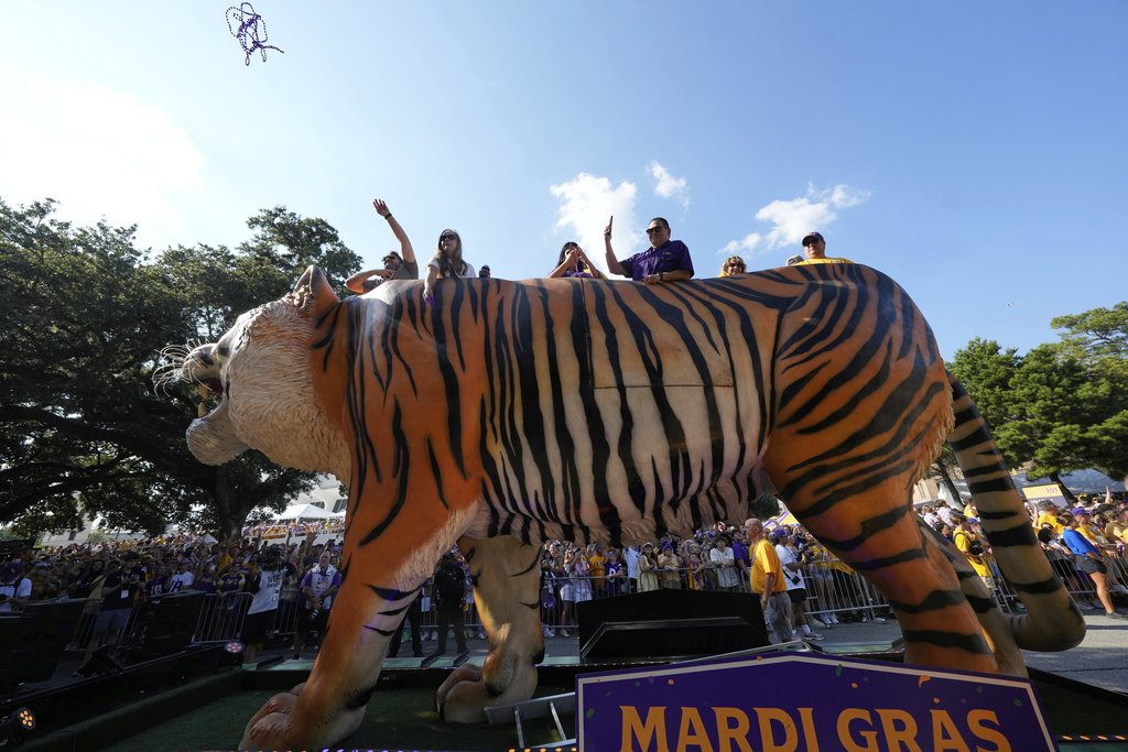 People throw beads from a tiger float outside Tiger Stadium before an NCAA college football game between LSU and Florida, Saturday, Sept. 13, 2025 in Baton Rouge, La. (AP Photo/Gerald Herbert)