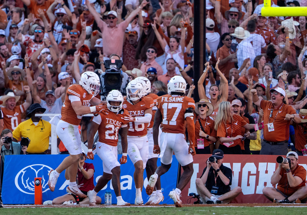 Texas punt returner Ryan Niblett (21) celebrates with teammates after returning a punt for a touchdown during the second half of an NCAA college football game against Oklahoma, Saturday, Oct. 11, 2025, in Dallas. (AP Photo/Jeffrey McWhorter)